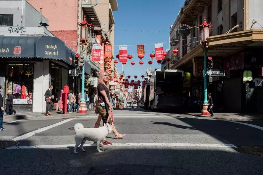 那克鲁兹和她的狗在唐人街散步.