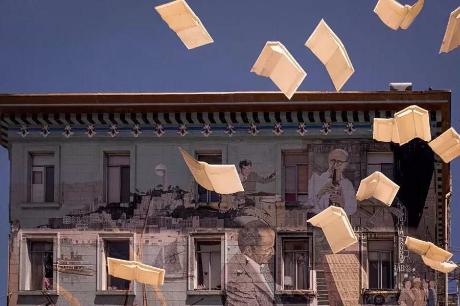 贝博体彩app城市灯光书店的外部照片, 展示一幅由书和浮动纸组成的壁画.