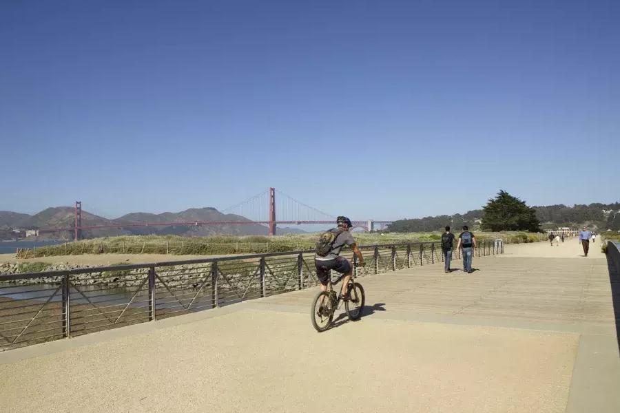 Um homem anda de bicicleta por uma trilha em Crissy Field. São Francisco, Califórnia.