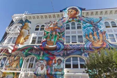 Ein farbenfrohes, großformatiges Wandgemälde bedeckt die Seite des Women's Building im Mission District von San Francisco.